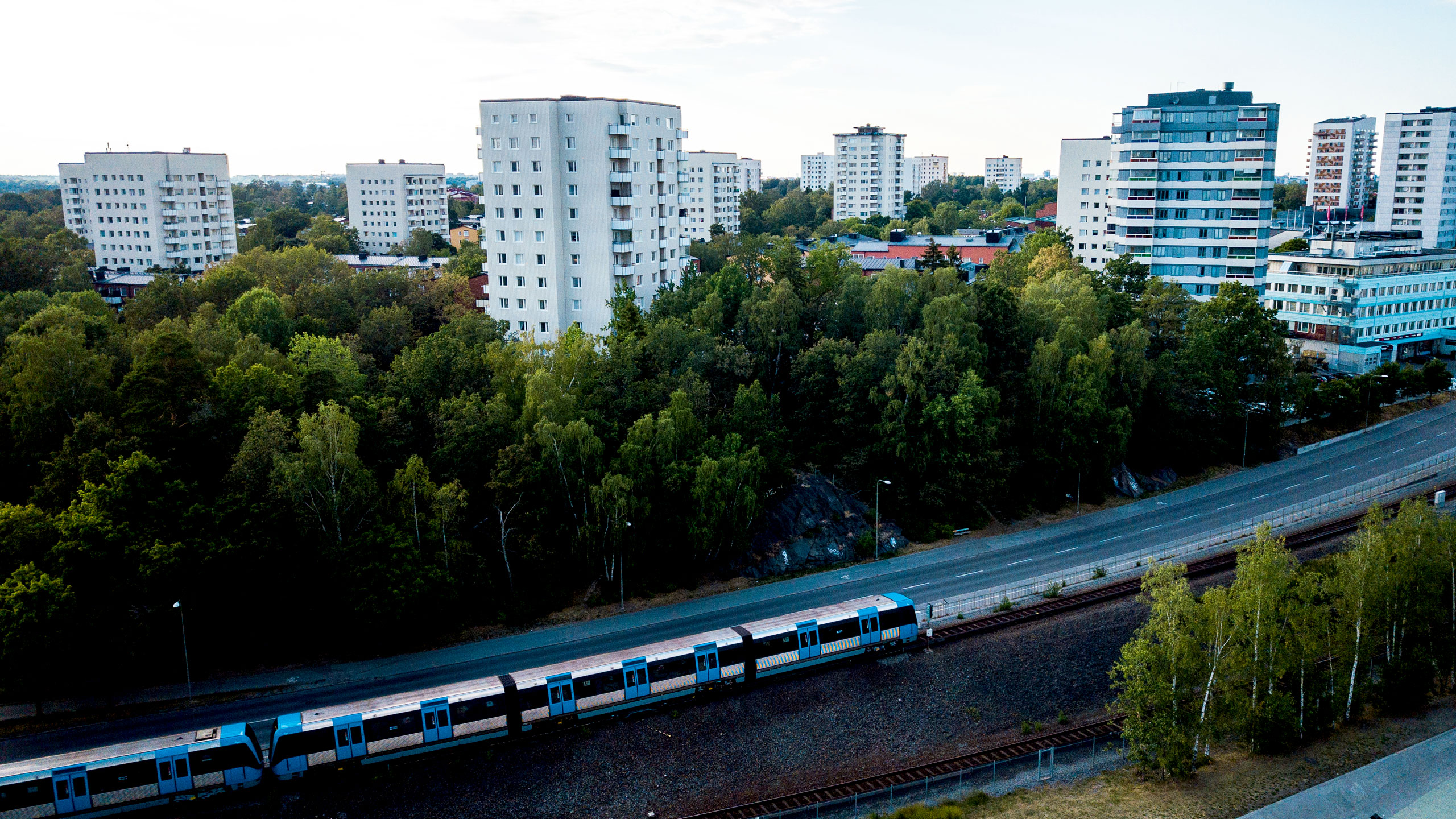 Vy över Högdalen med tunnelbana och grönområde i förgrunden.